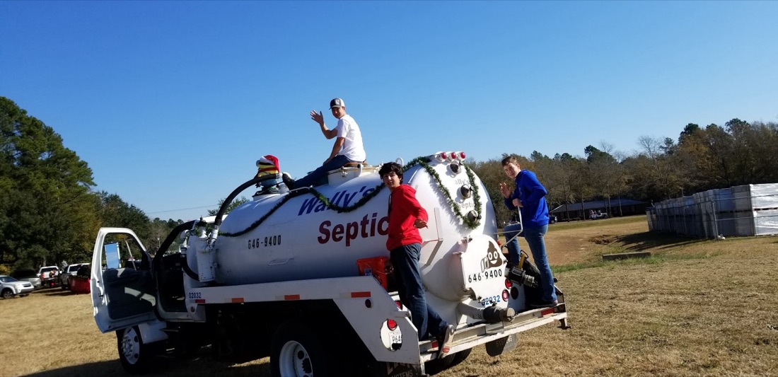 The crew riding on the back of the Wally's tank truck, waving