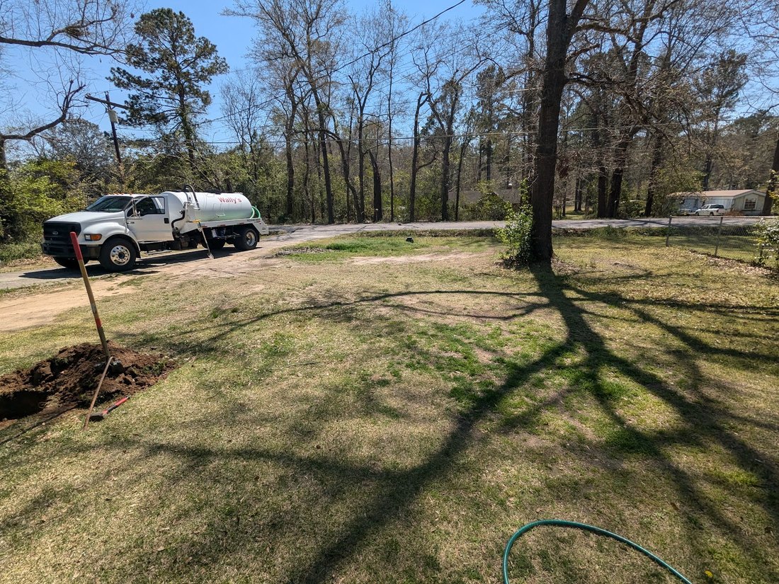 Wally's pump truck parked at a rural property with the ground already opened up